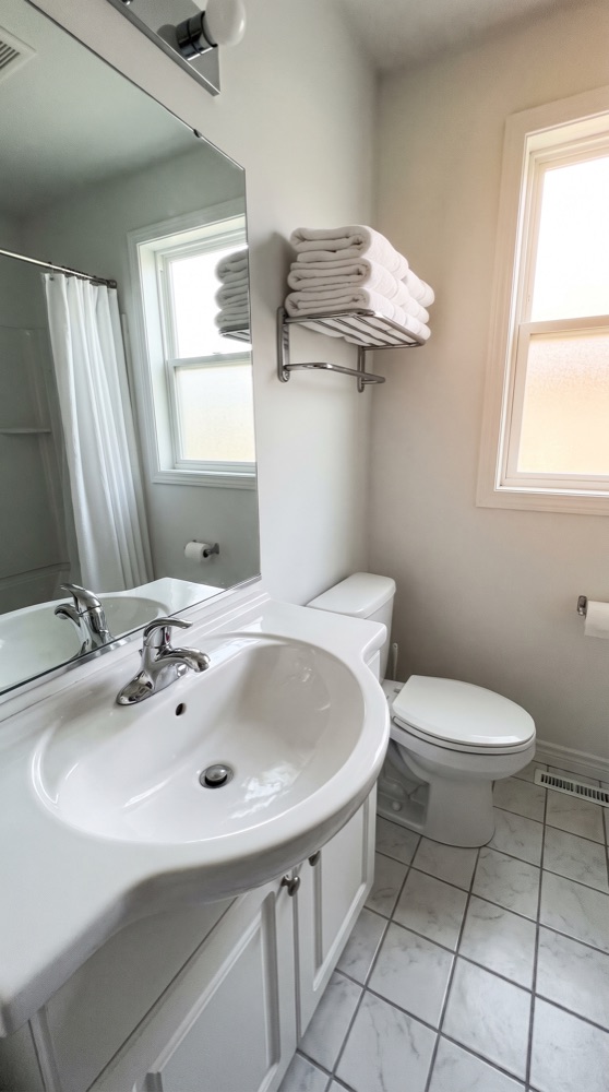 The same bathroom after cleaning, sparkling sink and mirror
