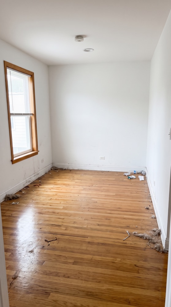 Empty room before move-out cleaning, dusty scuffed floor