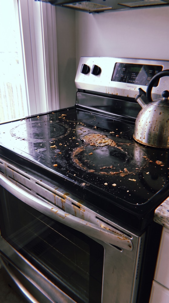 Stovetop before cleaning, burnt-on grease and food splatter